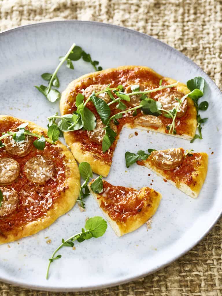 Mini-pizza met geroosterde paprika, verse worst en waterkers