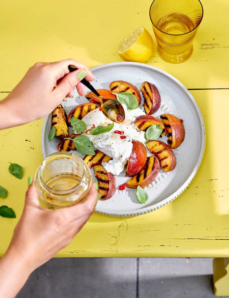 Salade met gegrilde perzik, burrata, basilicum en pittige honing