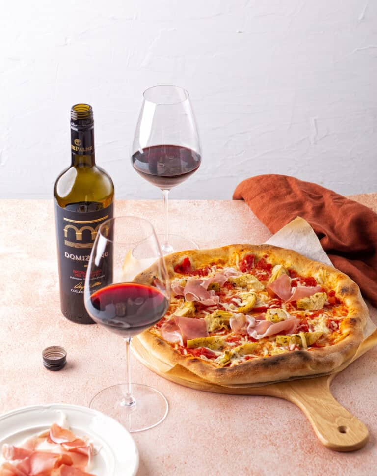 Pizza met tomaat, artisjok, prosciutto en pecorino