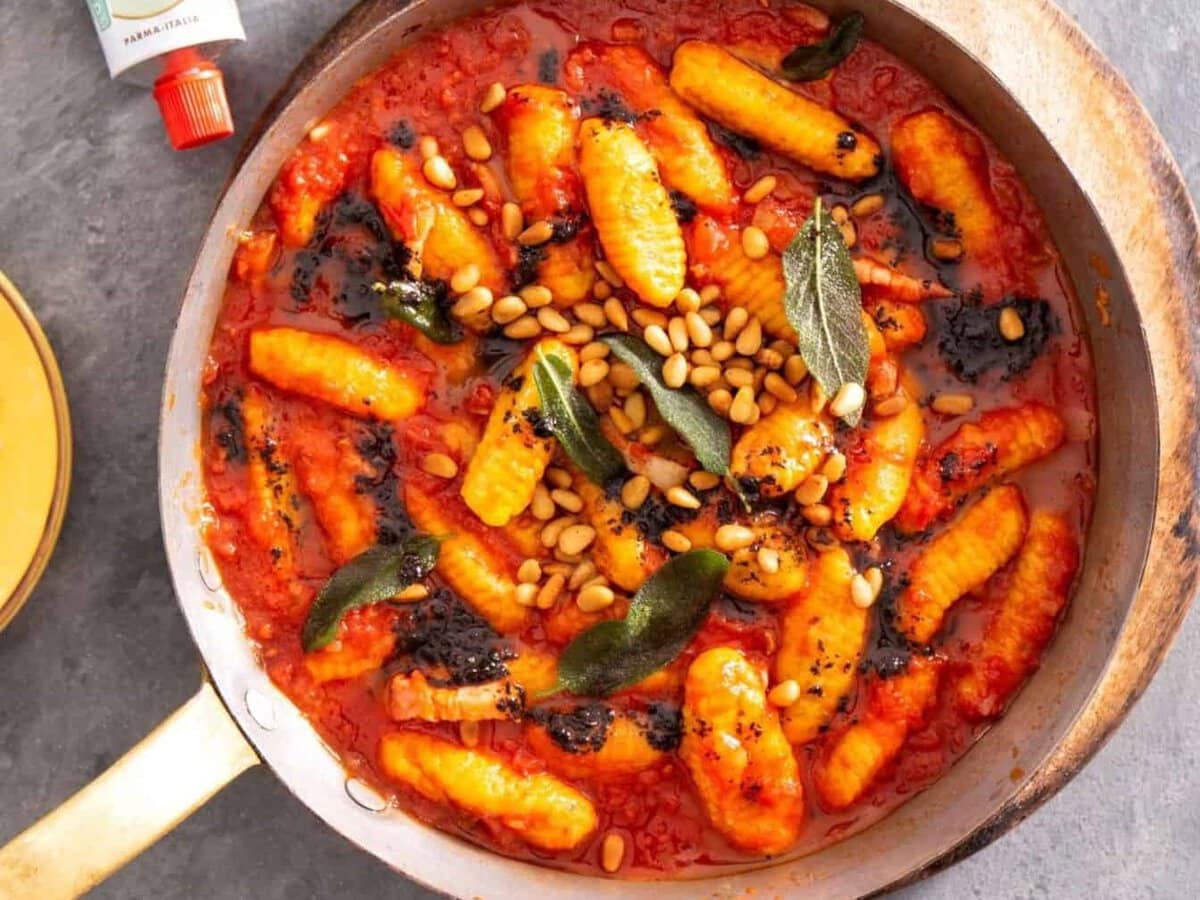 Pompoengnocchi in tomatensaus met zwarteknoflookboter, pecorino en pijnboompitten