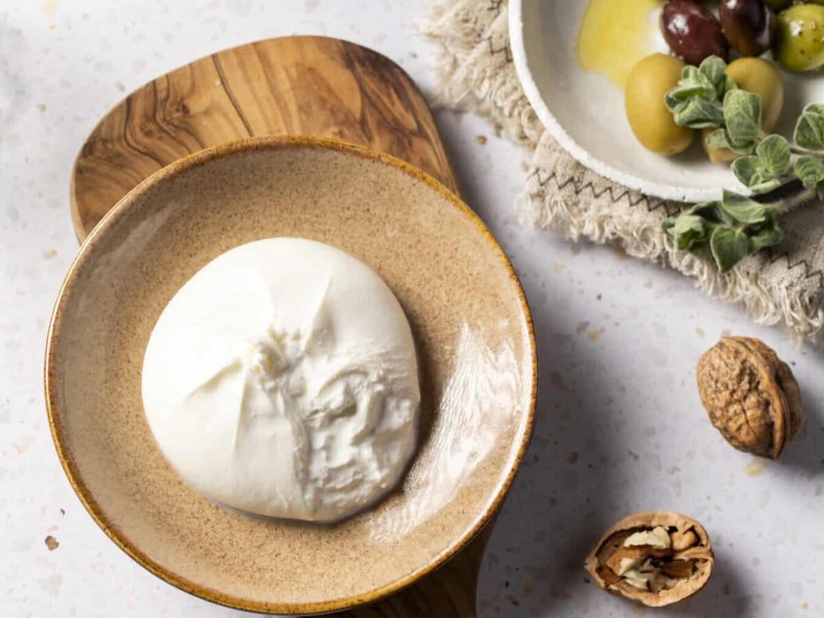 burrata op een bordje met olijven en noten