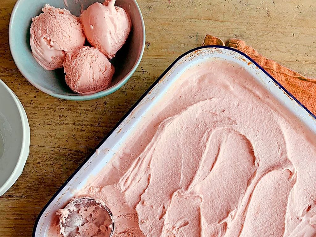 Bak aardbeienroomijs en een bakje met 3 bolletjes