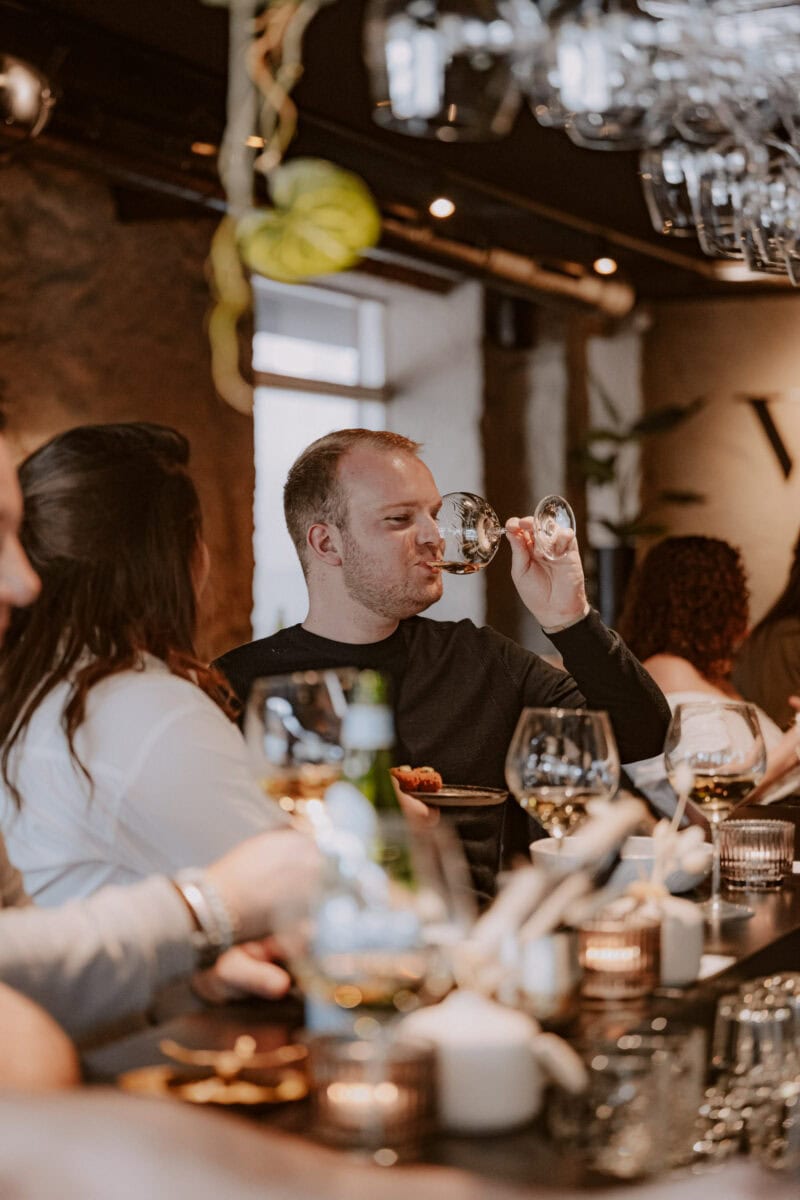 Man drinkt glas witte wijn bij Vine Wijnbar in Tilburg