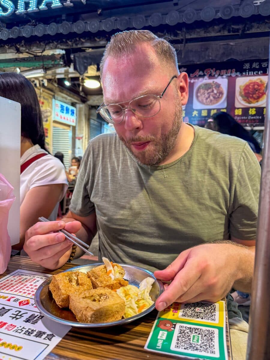 Bas Erkens eet stinky tofu op de Raohe Night Market in Taipei, Taiwan
