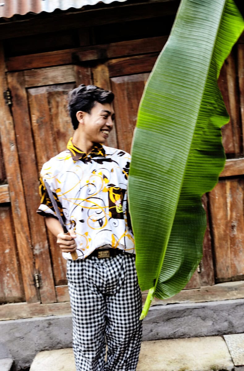 Man met een groot blad in zijn handen op Bali