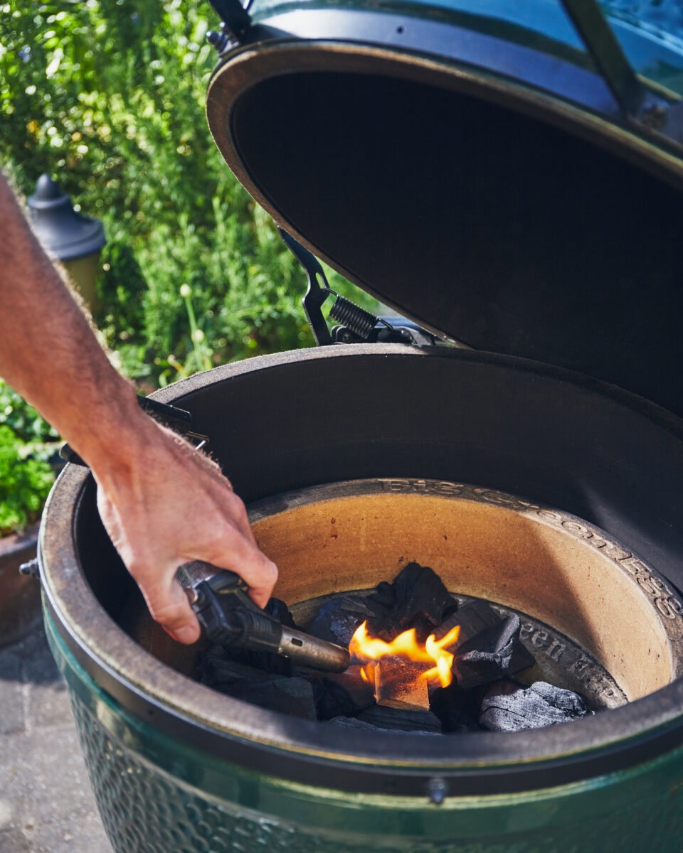 iemand die barbecue aansteekt
