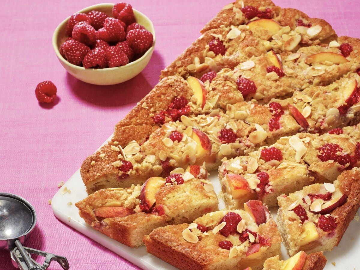 Amandelkruimelcake met perzik en frambozen in stukjes