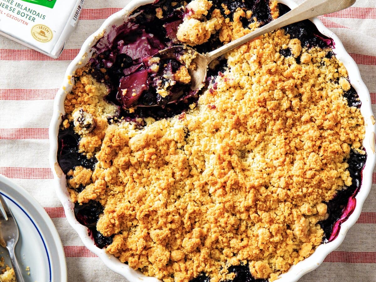 Ovenschaal met een crumble van peren en blauwe bessen met gezouten anijsboter