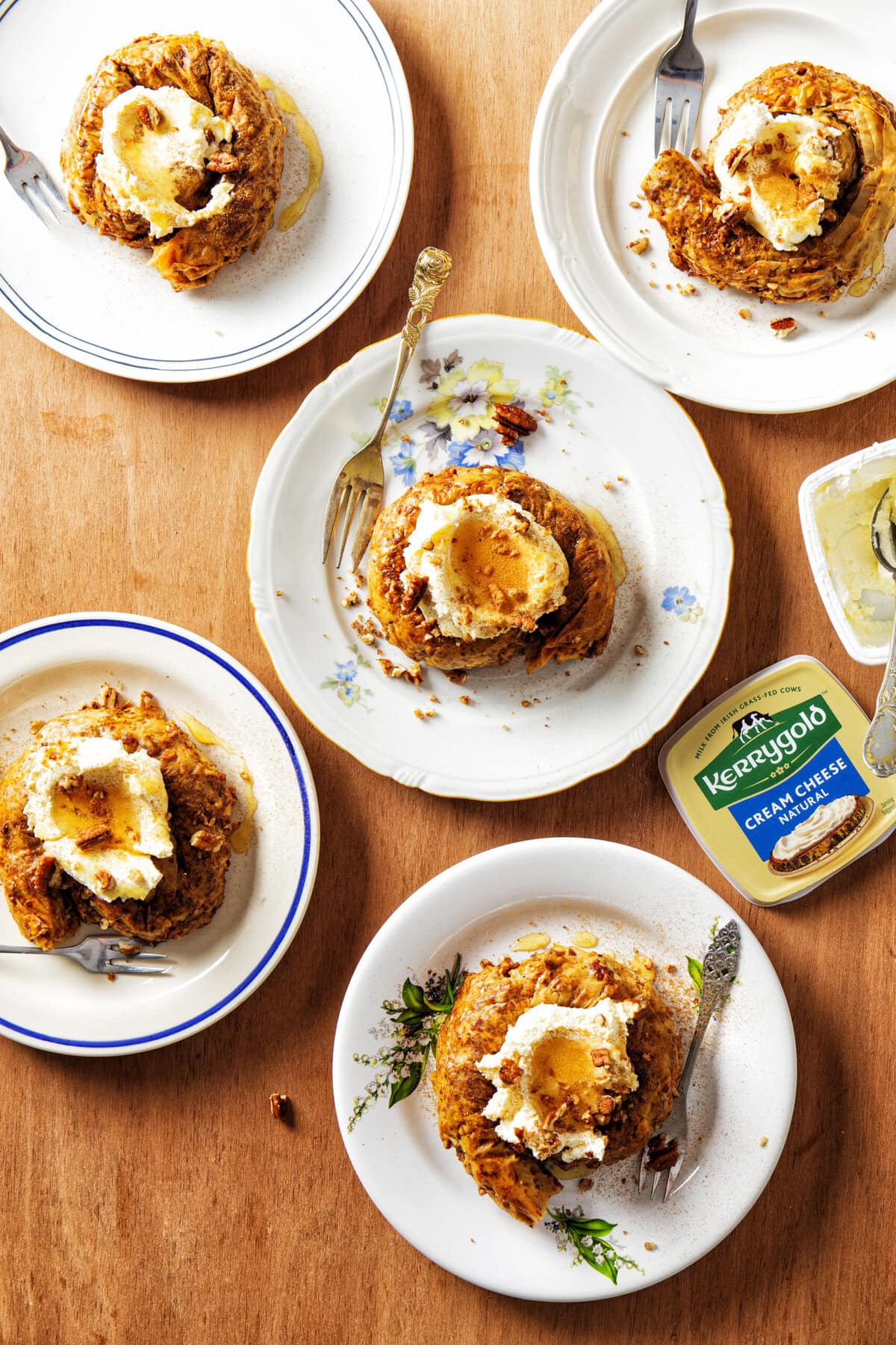 Filodeegknopen gevuld met kaneel, pecannoten en roomkaas met bovenop een toef roomkaas en kaneel