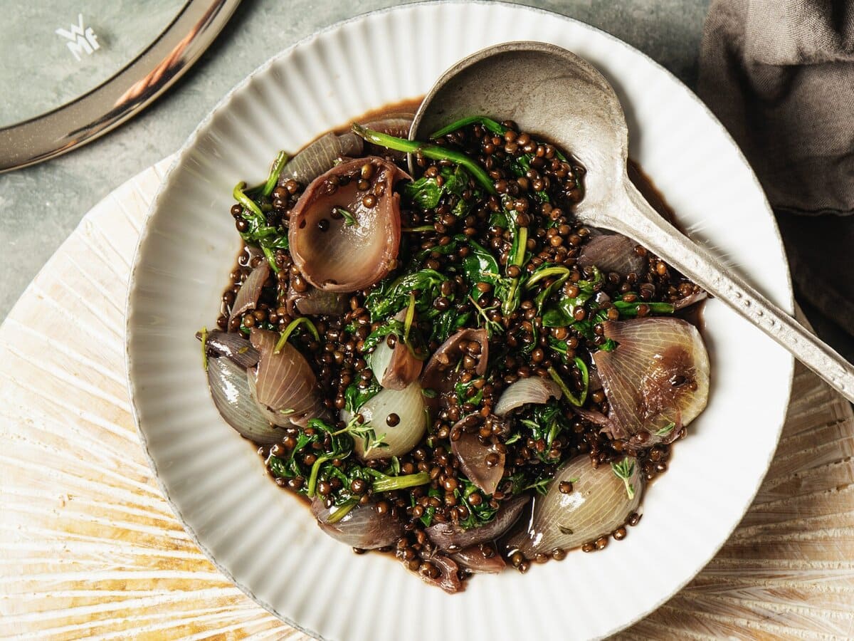 bord met gesmoorde uitjes en linzen