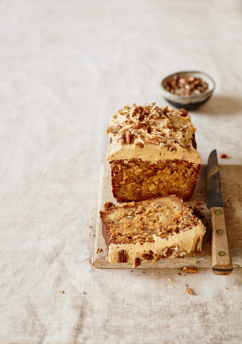 Ananas-banaan-harissacake met een laag botercrème en pecannoten erop