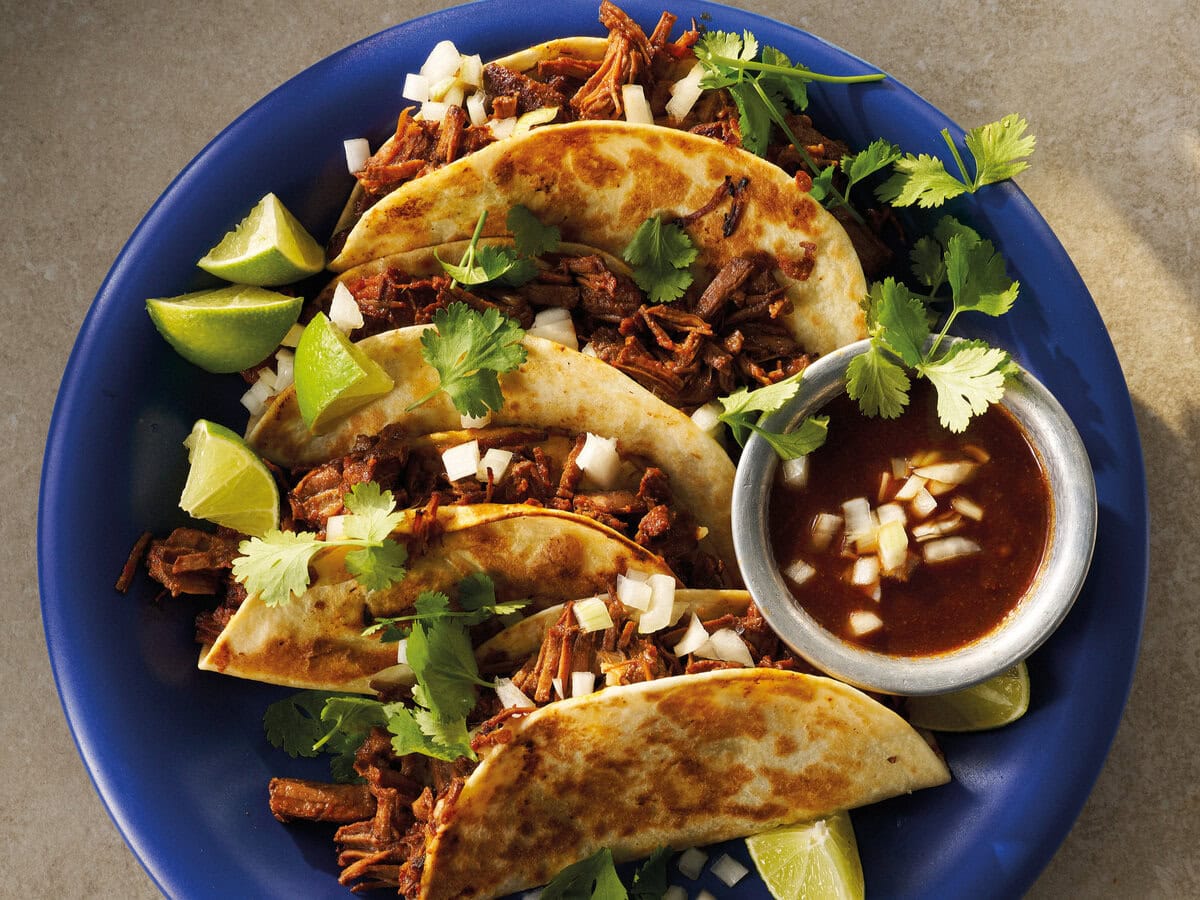 Birria tacos op een bord met saus