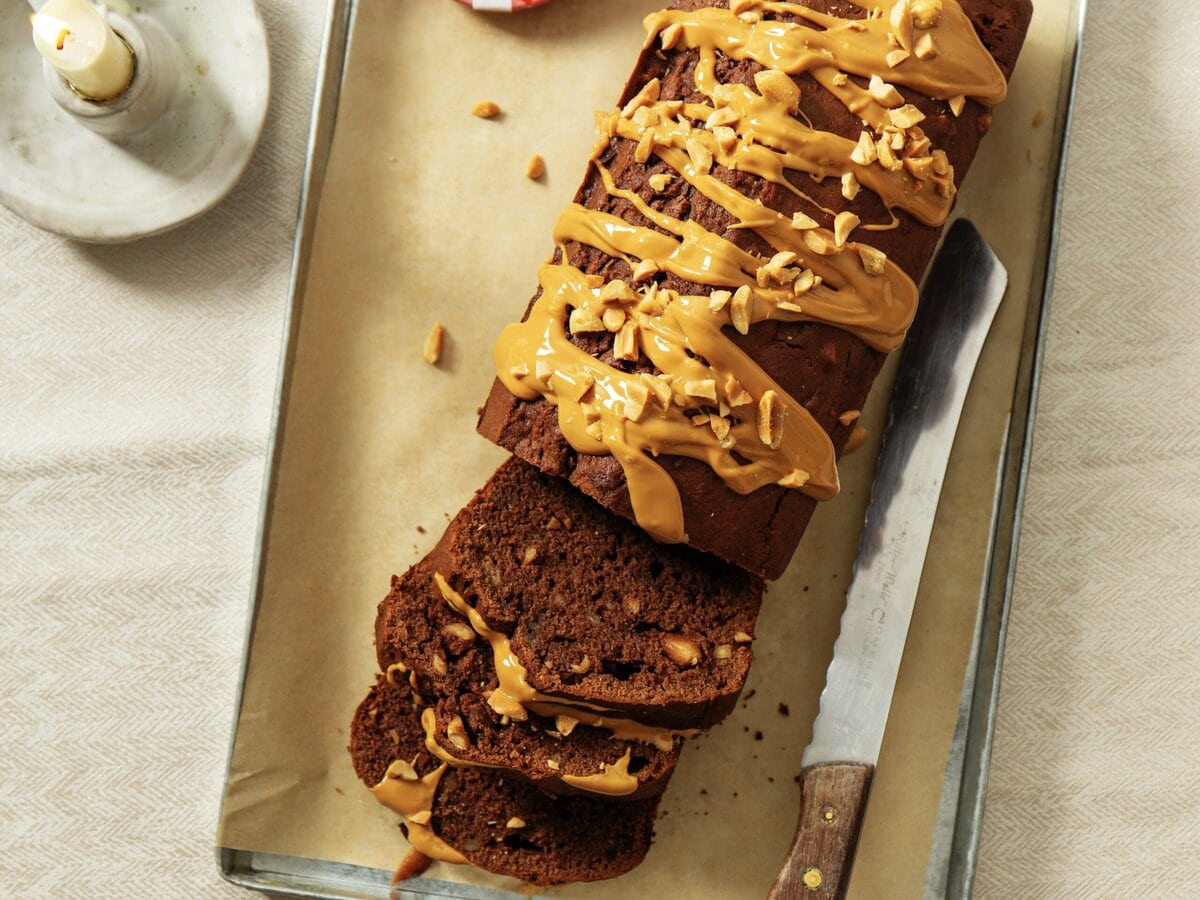 Choco-bananencake met daarover pindapasta en gehakte pinda's