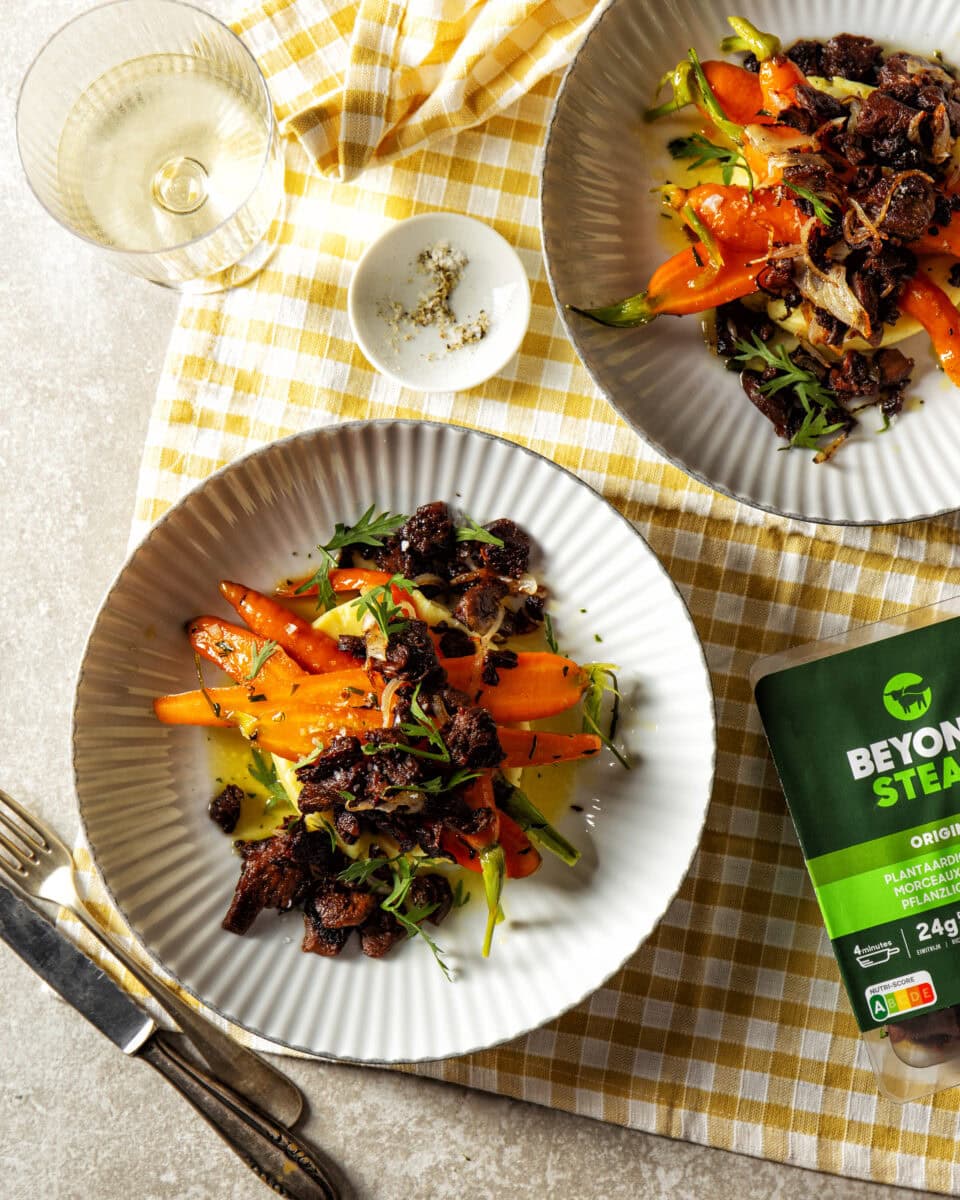 Geglaceerde wortel met dragonboter, aardappelpuree en daarop stukjes crispy Beyond Steak