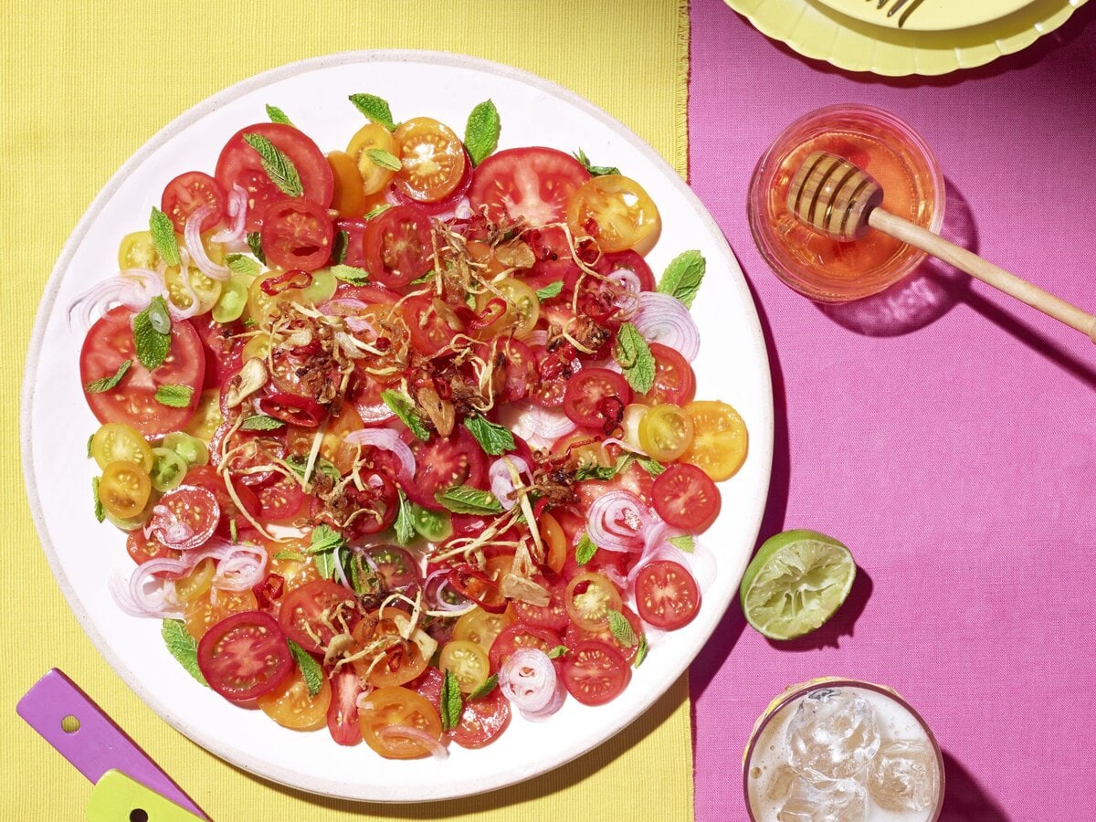 Tomaten-limoensalade met gember en knoflook op een bord met honing