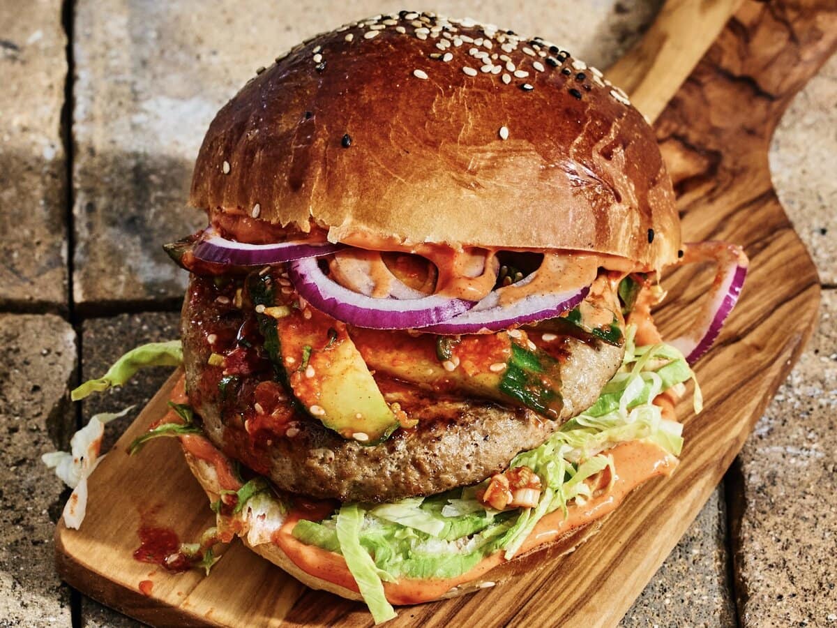 Koreaanse gochujang burger met onder andere komkommerkimchi, ui en sla