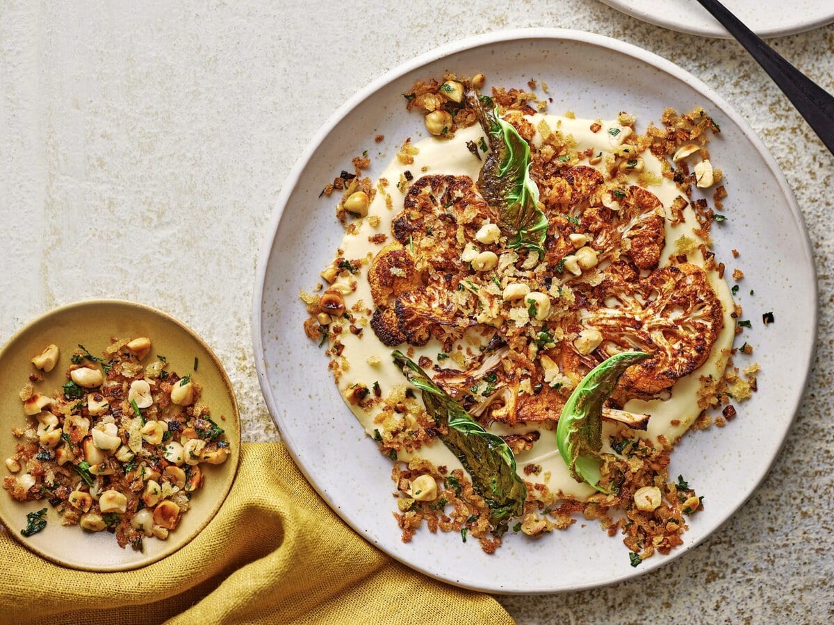 Bloemkoelpuree met daarop bloemkoolsteak, bloemkoolsaus en hazelnoottopping