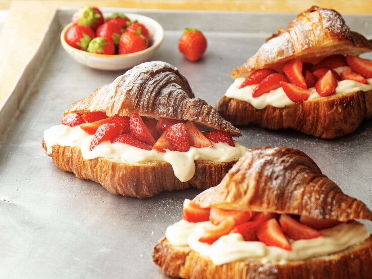 Drie croissants met een laagje room en aardbeien ertussen