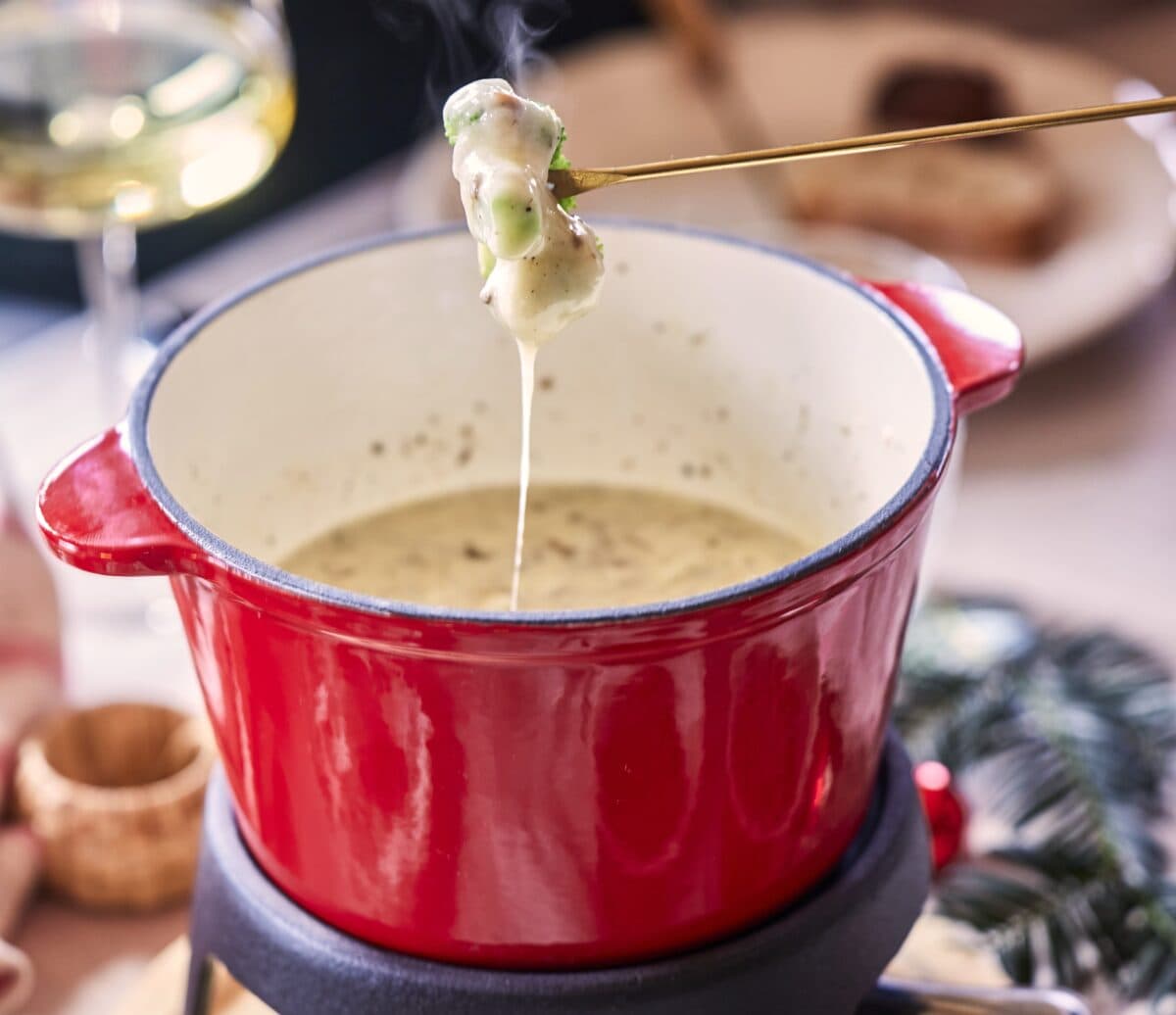 Eten dippen in een pan met kaasfondue