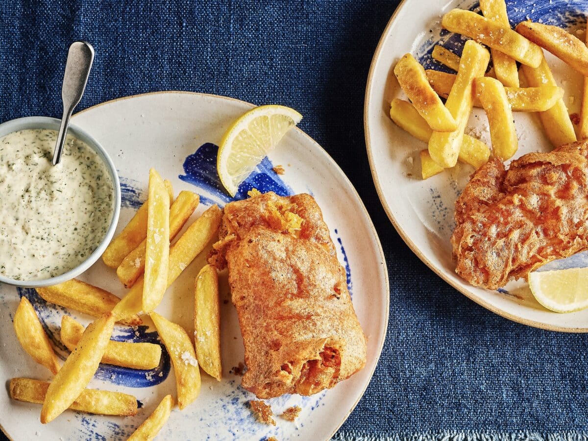 Kabeljauw met bierkorstje en zelfgemaakte tartaarsaus, met daarnaast frietjes en een partje citroen