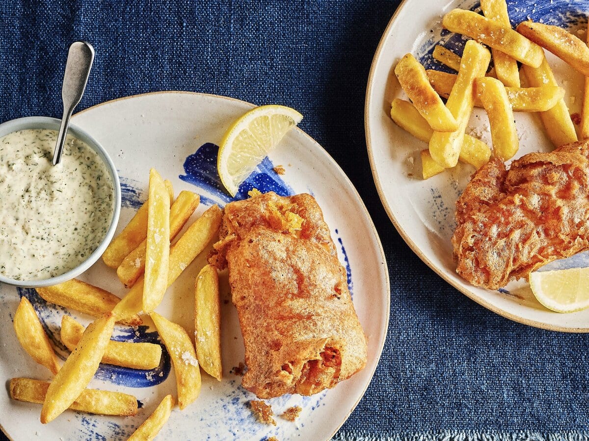 Kabeljauw met bierkorstje en zelfgemaakte tartaarsaus, met daarnaast frietjes en een partje citroen