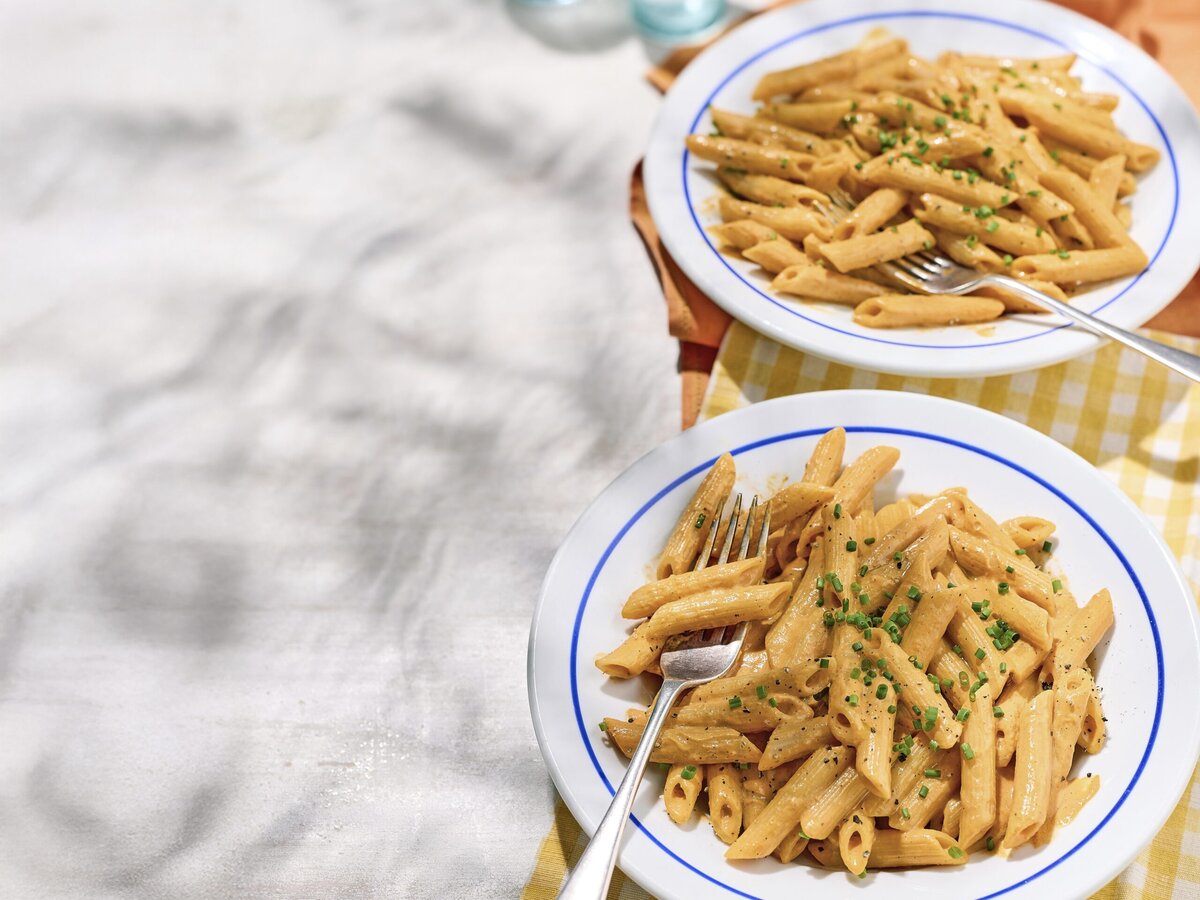 Pasta in een saus van geroosterdepaprikasaus met daarover bieslook