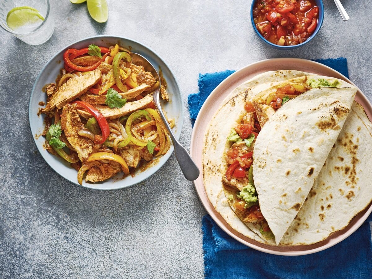 Schaaltje met kip, paprika en koriander uit de slowcooker met daarnaast wraps