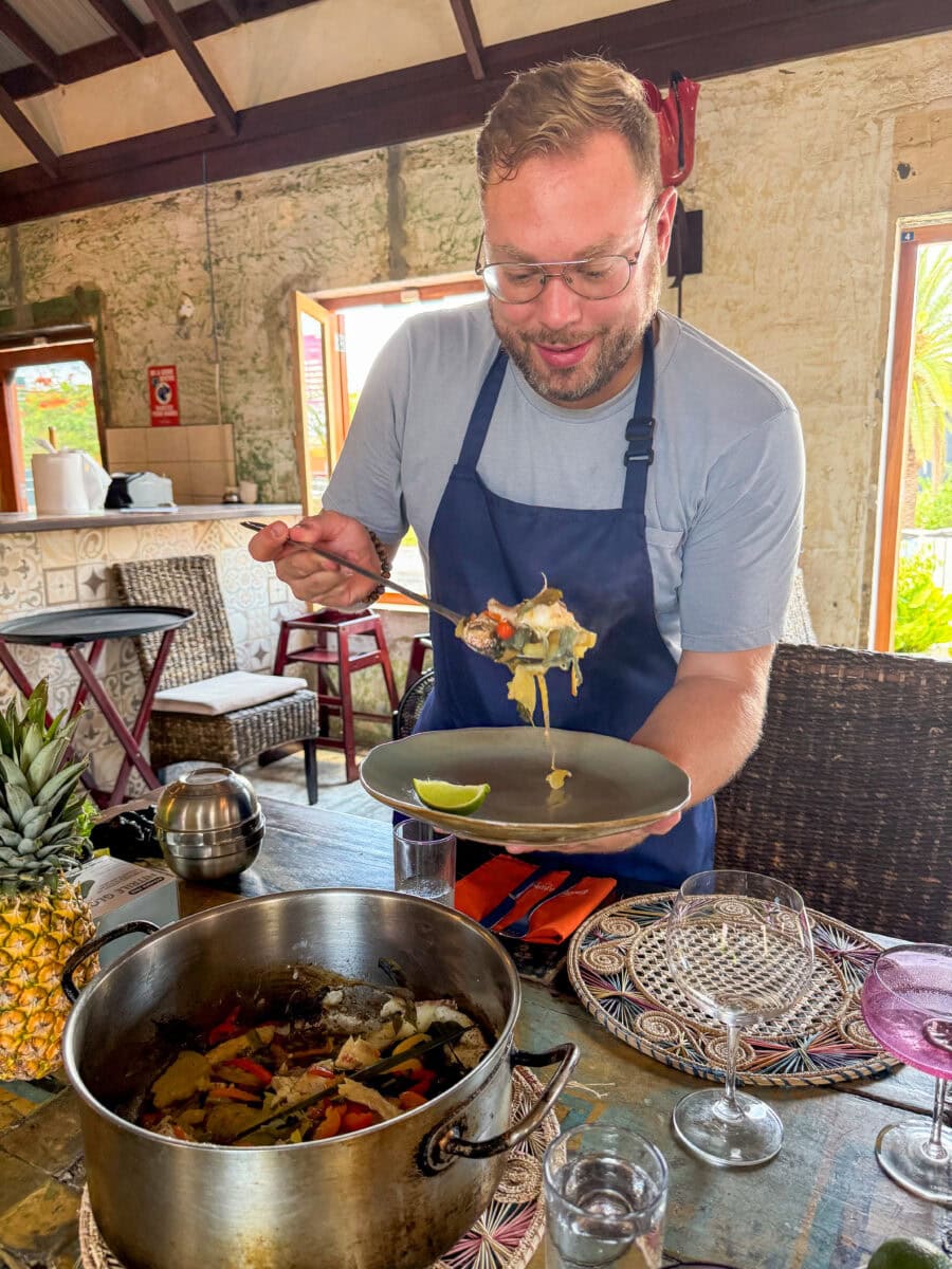 Bas schept pescabi smoor op bij een restaurant op Aruba