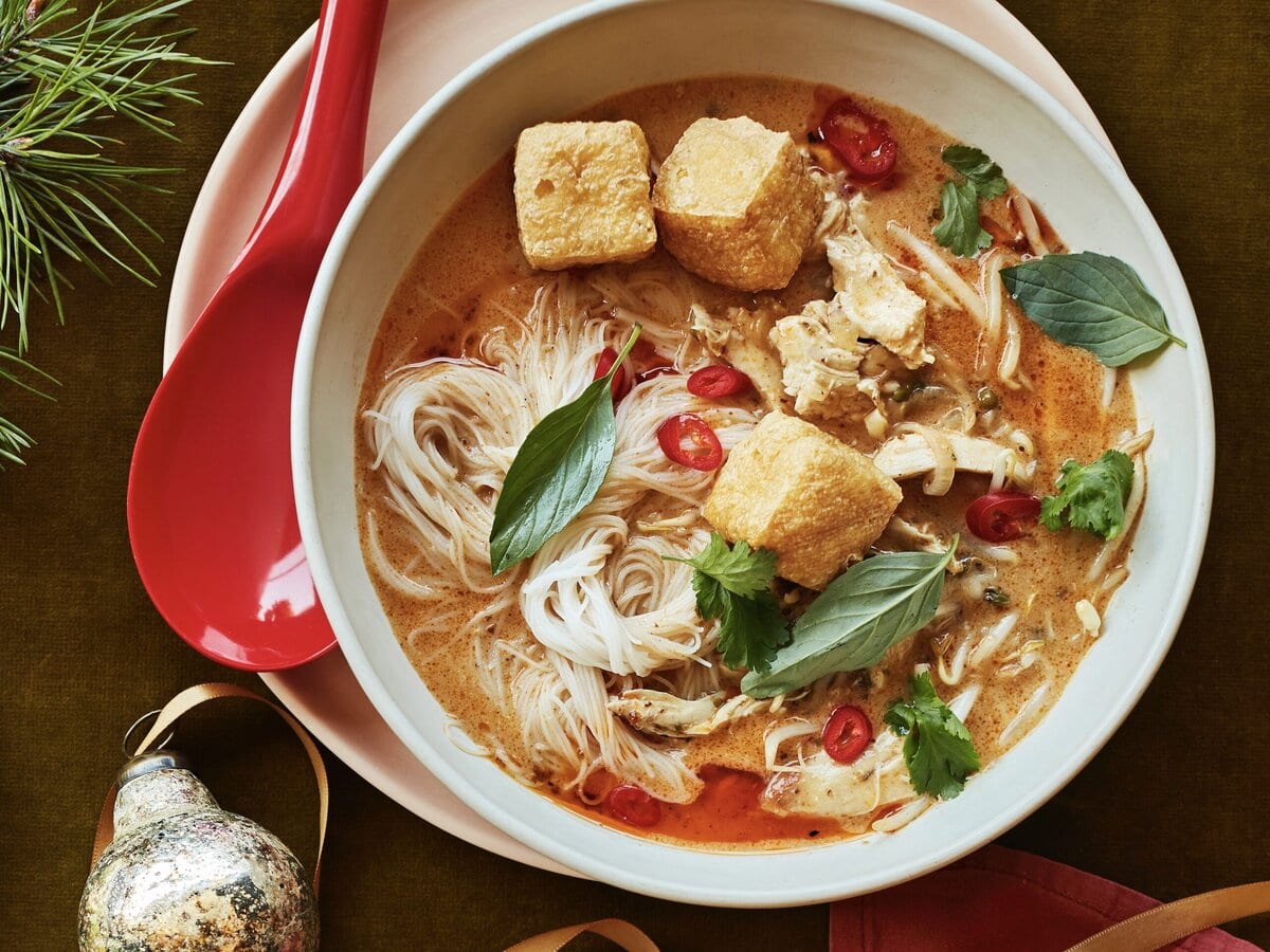 Twee kommen currynoedelsoep met kalkoen, sereh, tofu, rode peper en Thais basilicum