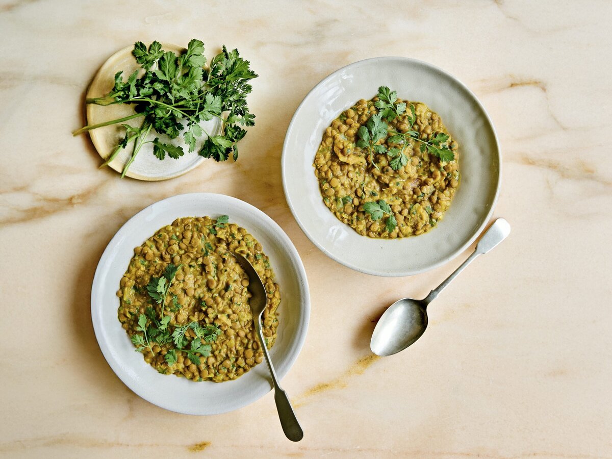 Twee bakjes dahl met gember en lime pickle met daarover koriander