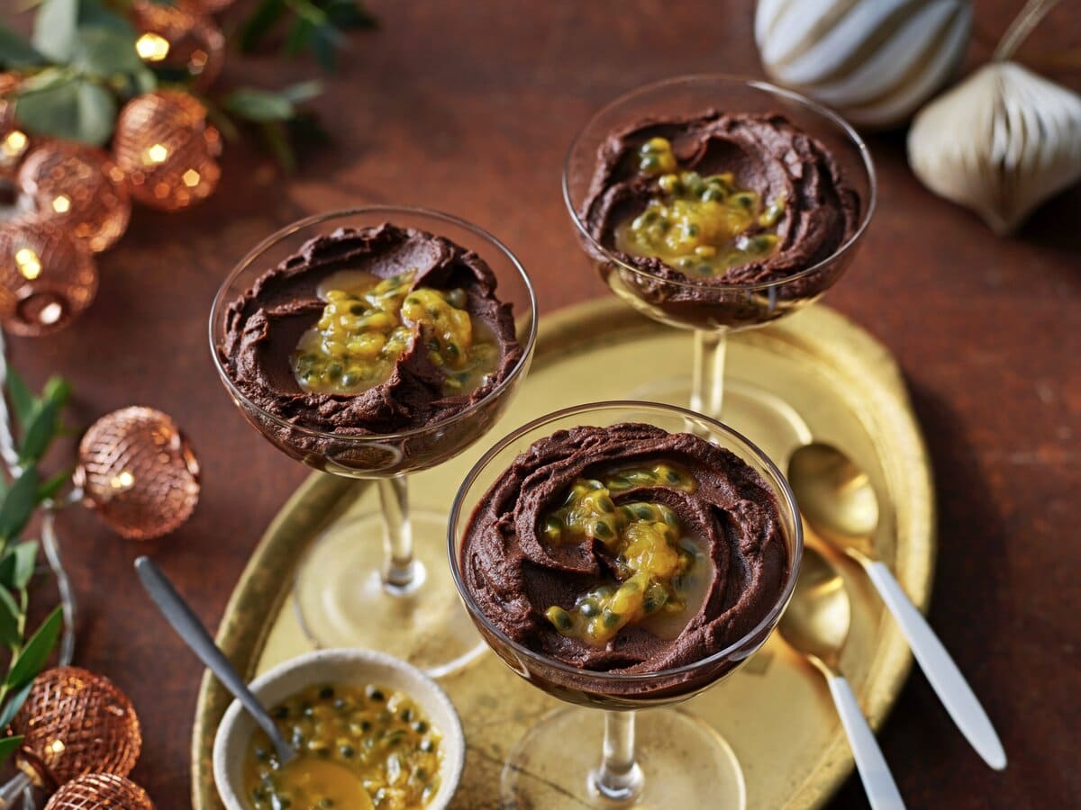 Drie glaasjes dikke chocolademousse met passievrucht erover
