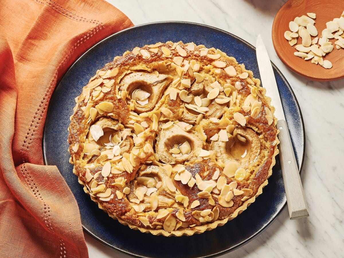 Peer-amandeltaart met gember en bovenop amandelschaafsel