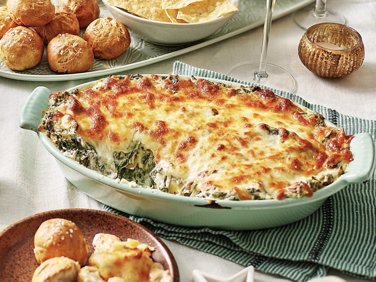 Spinazie-artisjokdip met een laag kaas erover