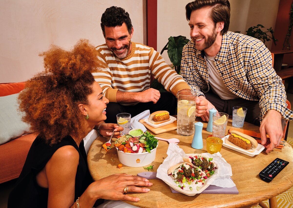 mensen eten aan tafel van Thuisbezorgd bestellingen