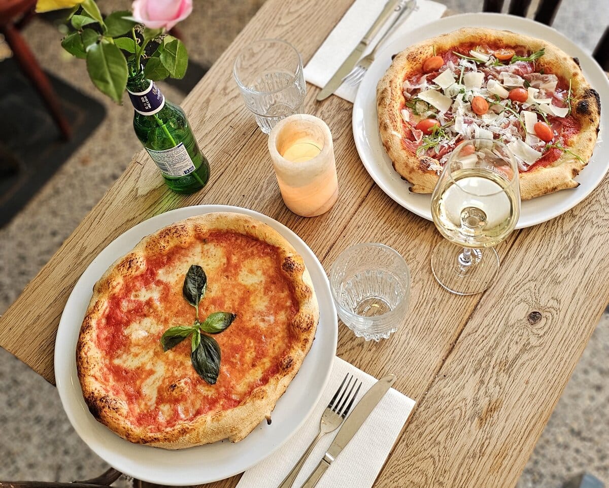 Twee pizza's uitgeserveerd bij een pizzeria