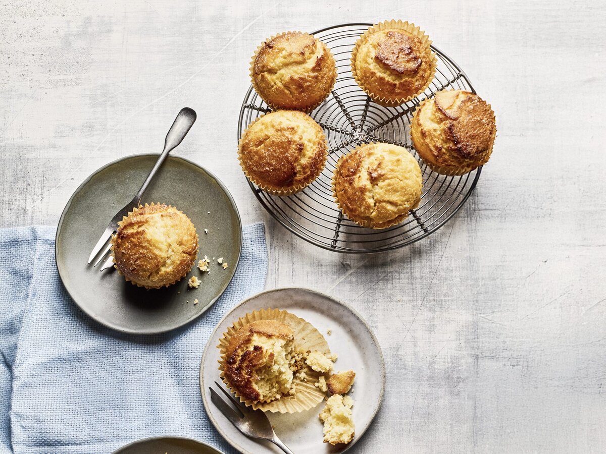 Frisse citroenmuffins op een rooster en drie muffins op een bordje