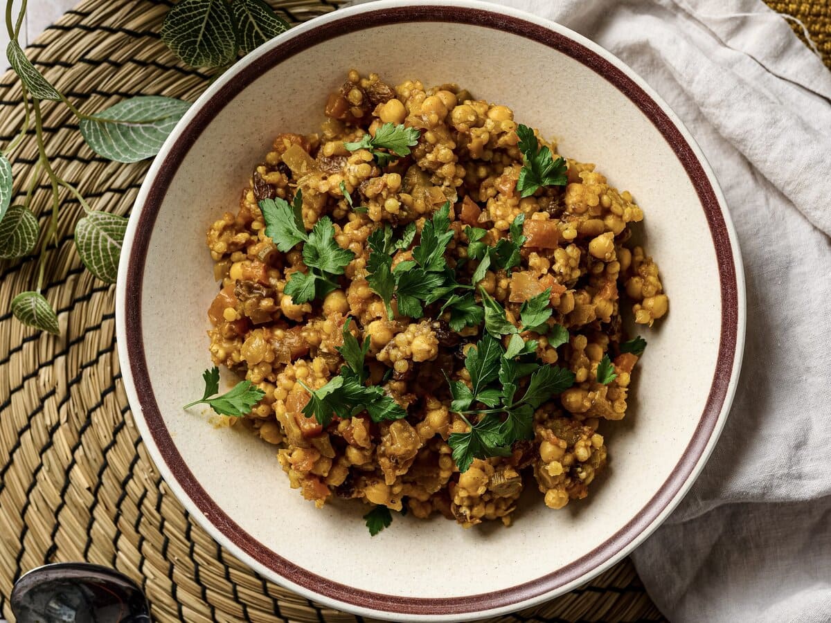 Marokkaanse parelcouscousstoof met rozijnen en daarover koriander