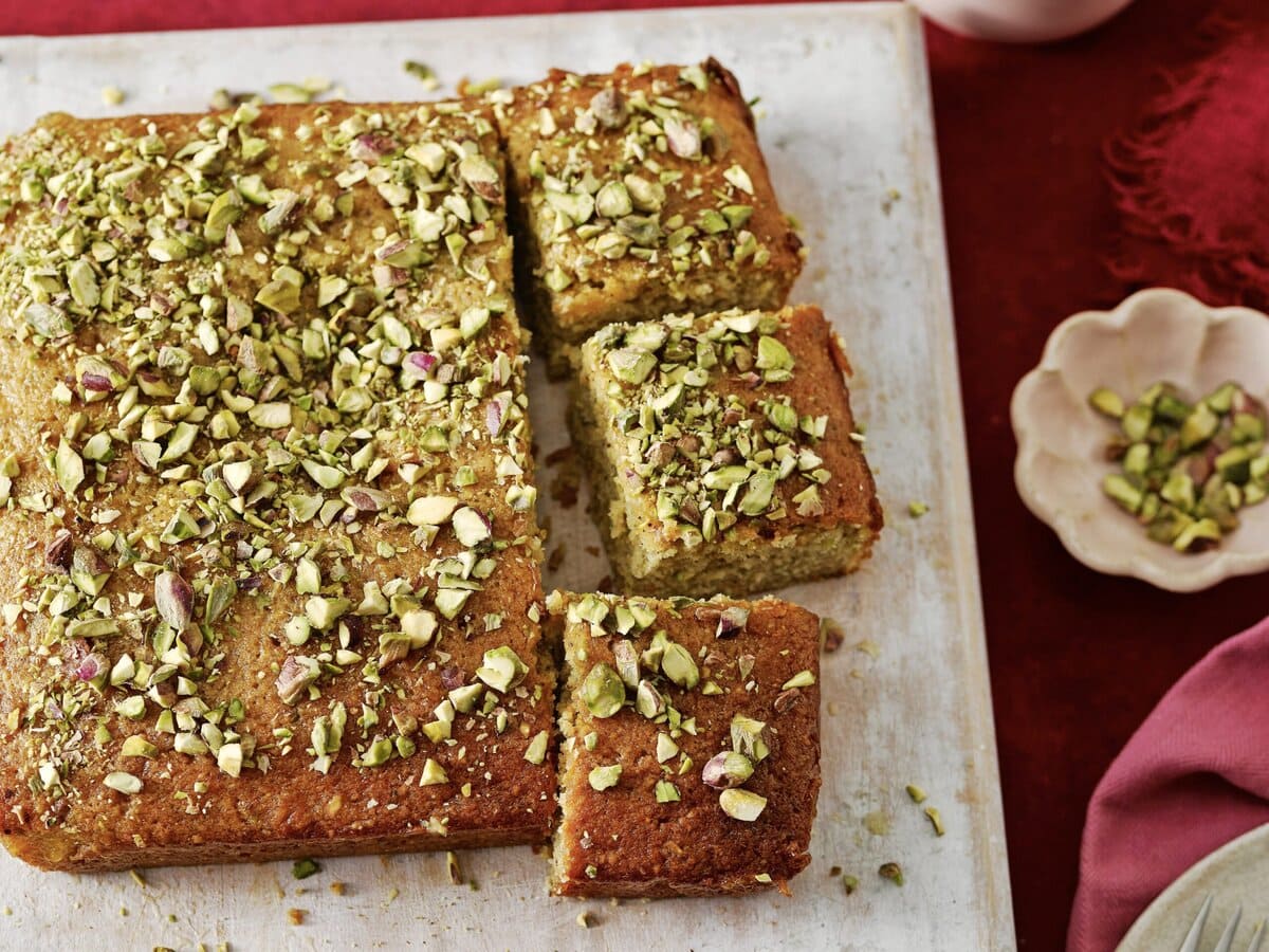 Pistache-bloedsinaasappelcake bestrooid met pistache, in een paar stukken