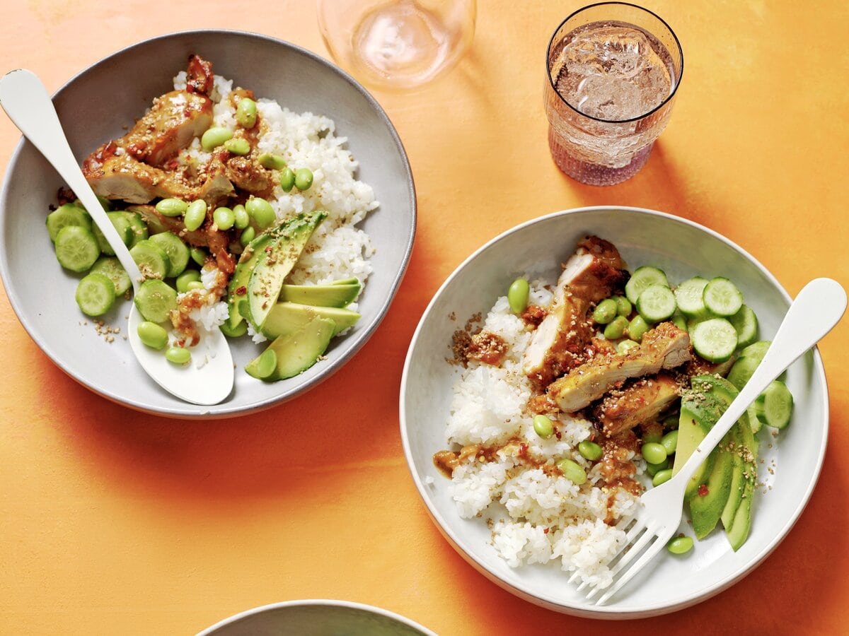 2 rijstbowls met pindakaas-kurkumakip, edamamebonen, avocado en komkommer
