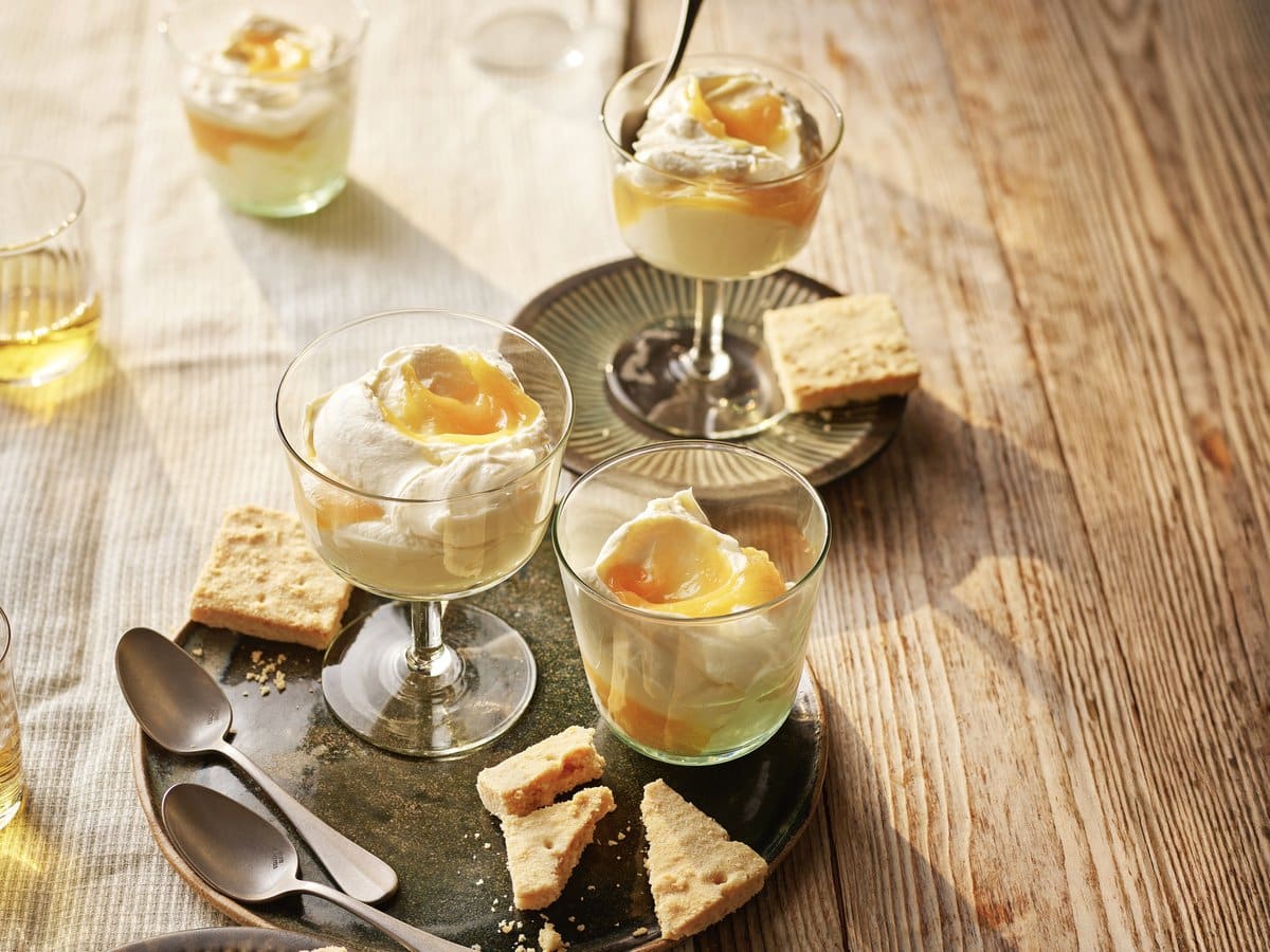 Roomyoghurt met lemoncurd in glaasjes, geserveerd met koekjes