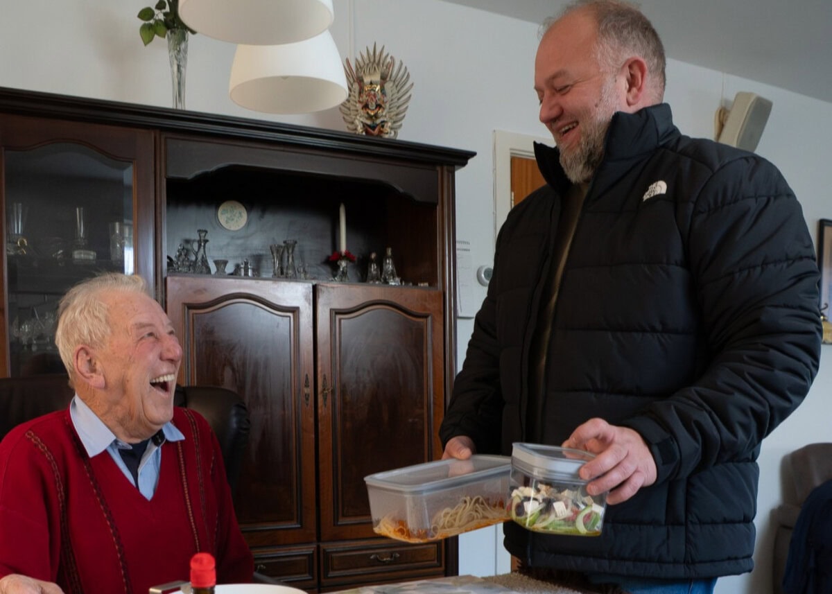 Twee mannen die eten uitwisselen voor stichting Thuisgekookt