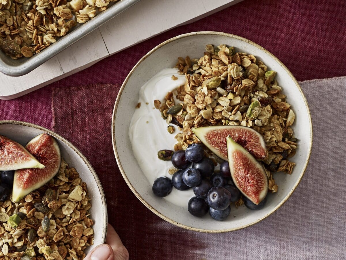 Tahin-pistachegranola geserveerd met yoghurt, bosbes en vijg