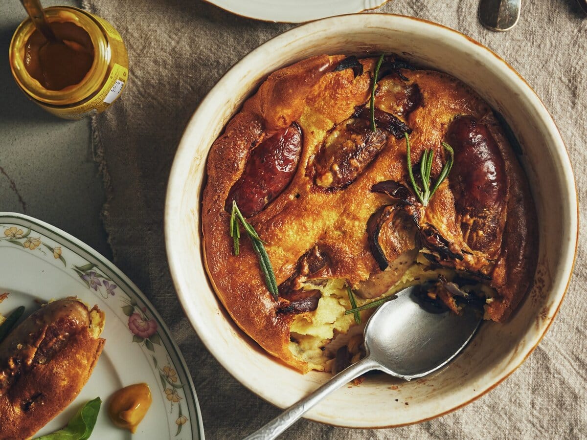Worstjes in luchtig pannenkoekbeslag met rozemarijn in een ovenschaal