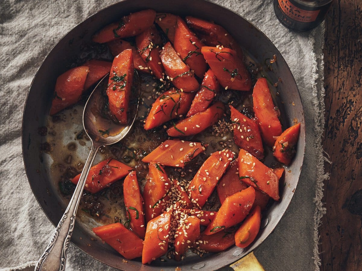 Wortels met worcestershire-glaze met daarover peterselie en geroosterd sesamzaad