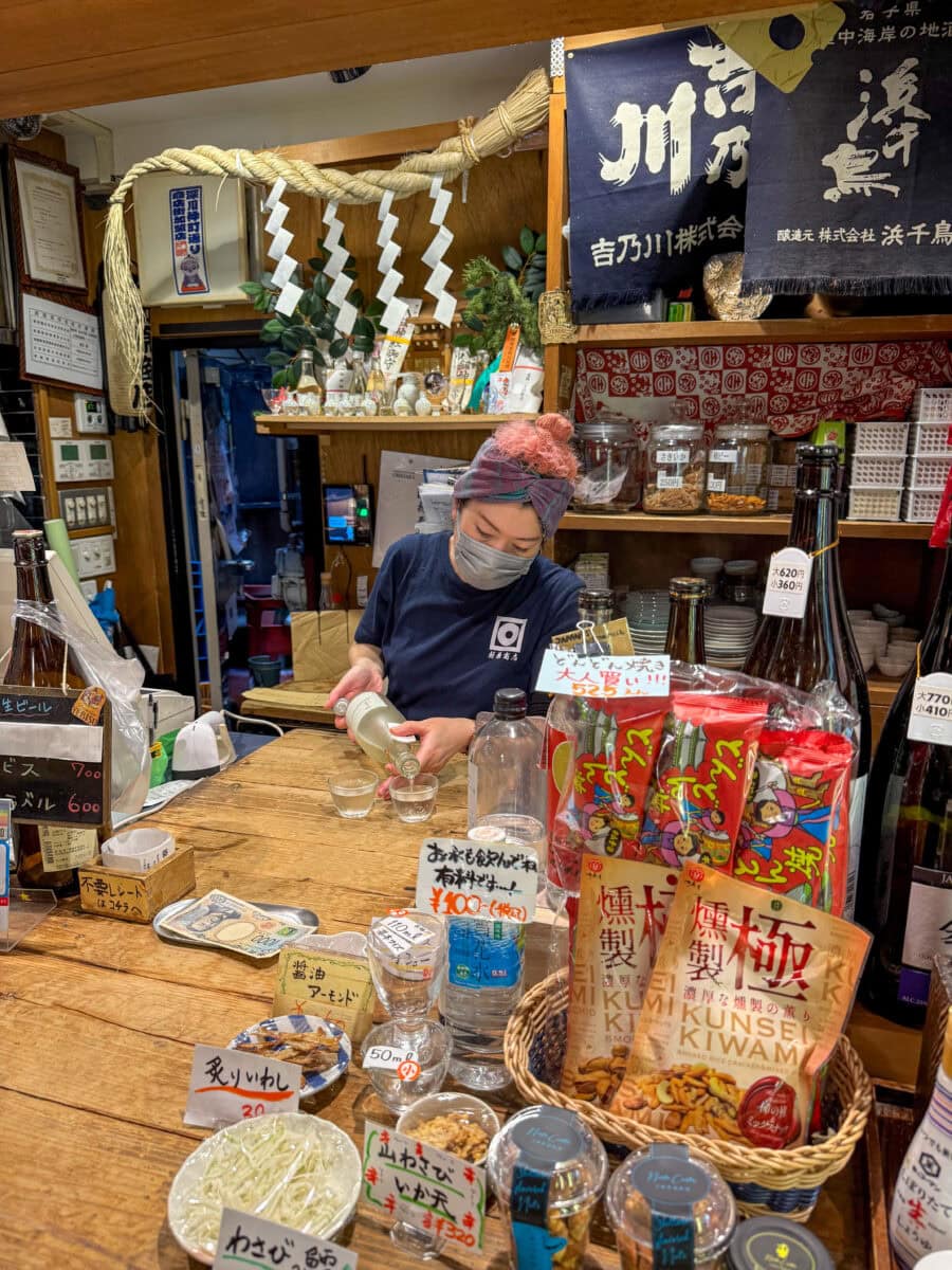 Sakebar waar een glas sake wordt ingeschonken in Tokio
