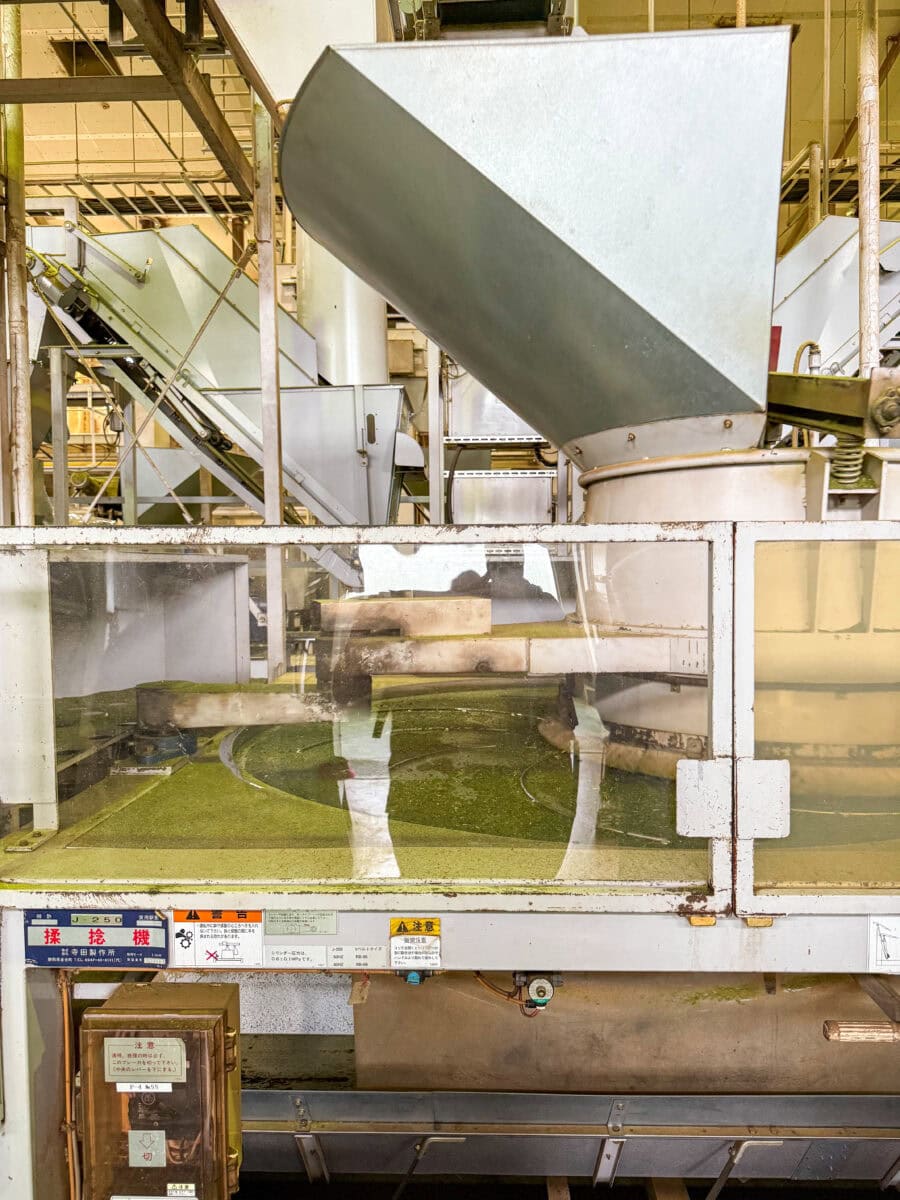 Grote borstel die theebladeren tot poeder verwerkt in Japan