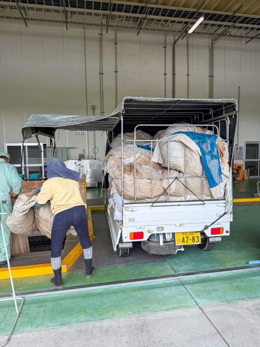 Boeren met zakken thee bij een theefabriek in Japan