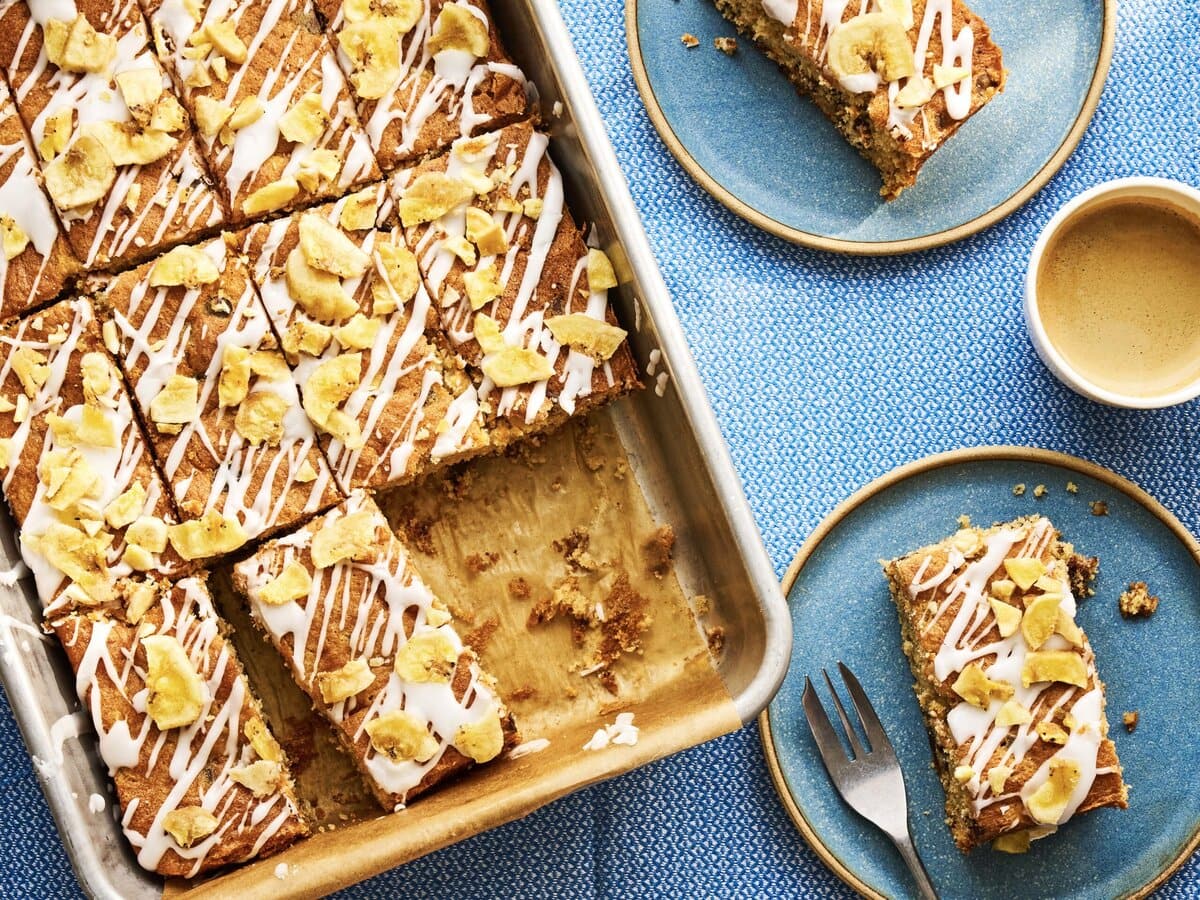 Banaan-chocoladeplaatcake met daarover icing en bananenchips in ovenschaal