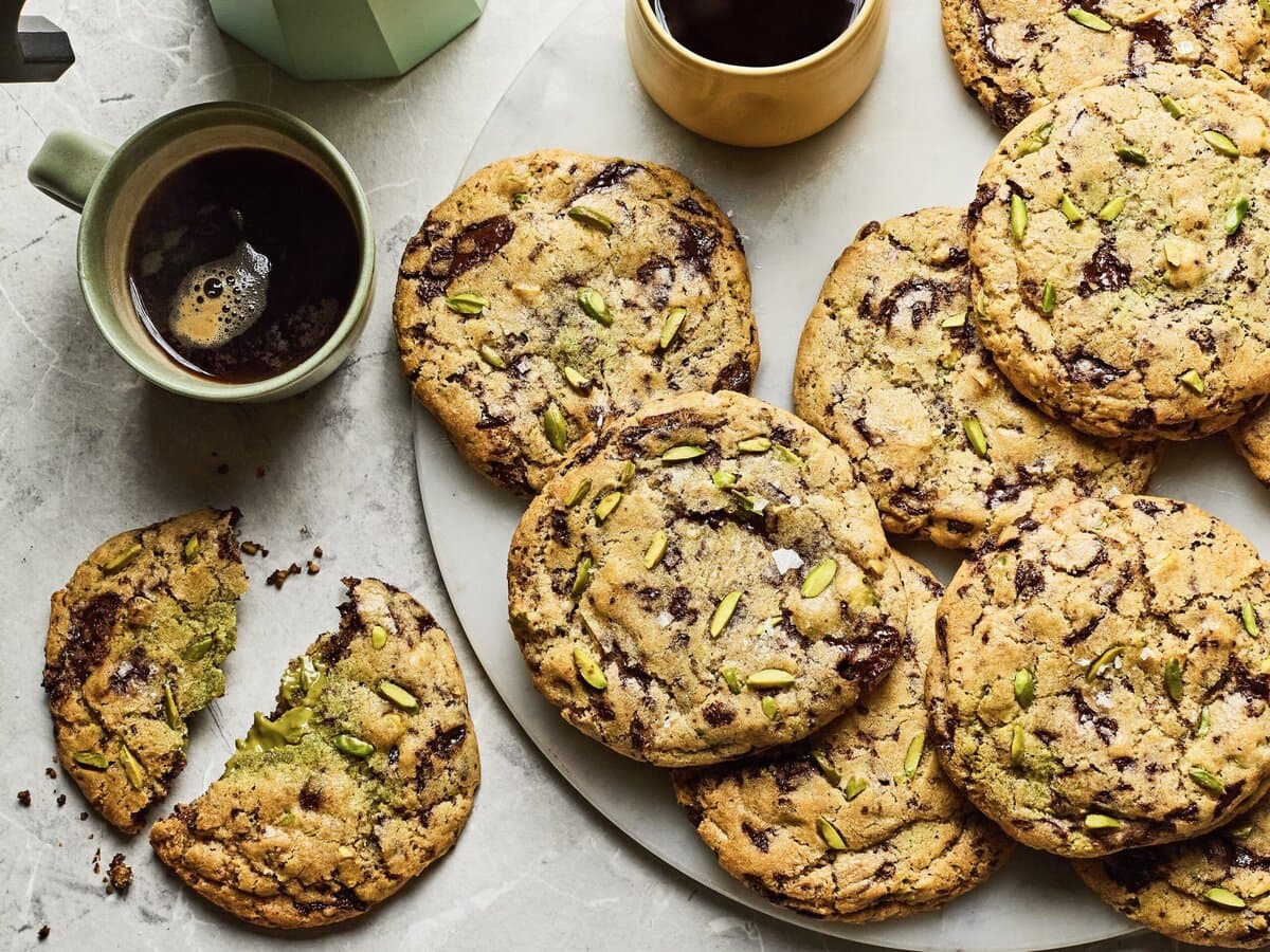 Chocolate chip cookies met pistache, geserveerd met kopjes koffie
