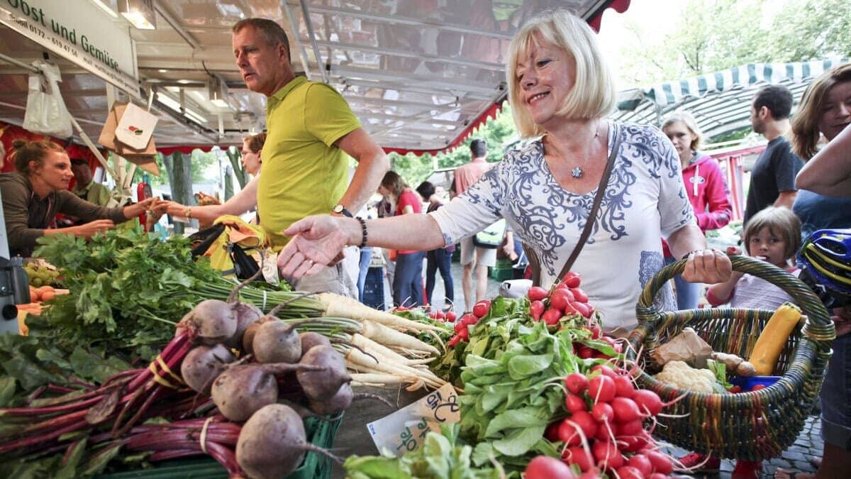 Mensen doen boodschappen op de weekmarkt in de Duitse stad Karlsruhe